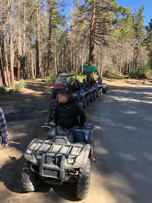 a group of people riding on a four wheeler on the road at Sequoia National Forest CabinG in Panorama Heights