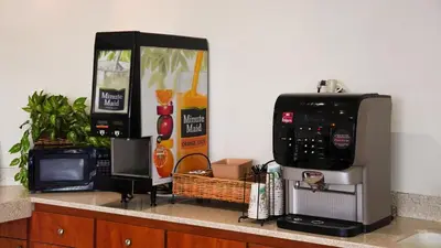 a kitchen counter with a microwave and a coffee maker at Country Inn Ontario in Ontario