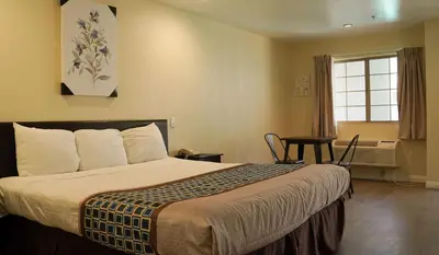 a hotel room with a bed and a table and a window at Country Inn Ontario in Ontario