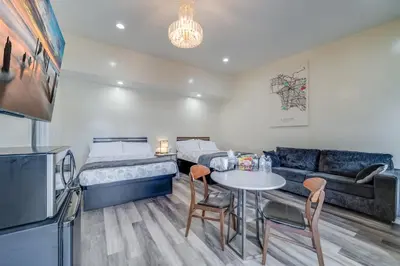 a room with two beds and a table and chairs at 24 Hours Motel in Los Angeles