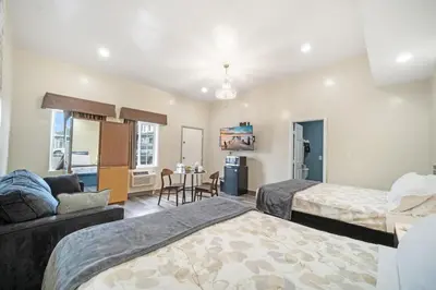 a hotel room with two beds and a living room at 24 Hours Motel in Los Angeles