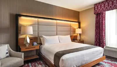 a hotel room with a large bed and a chair at Bear Springs Hotel in Highland
