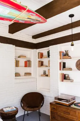 a room with a chair and shelves with books at The Venice Beach House in Los Angeles