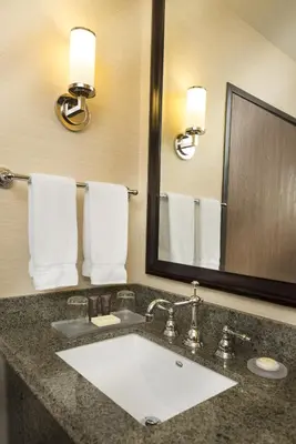 a bathroom with a sink and a mirror and towels at ALO Hotel by Ayres, Orange in Anaheim