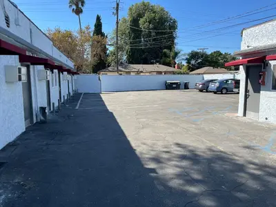 a parking lot next to a building with cars parked at Griffith Park Motel, in Los Angeles Hollywood Area in Glendale