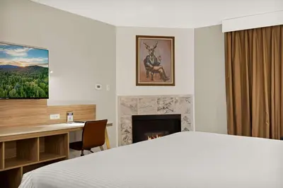 a bedroom with a bed and a desk and a fireplace at Chateau Big Bear Boutique Hotel, BW Signature Collection in Big Bear Lake