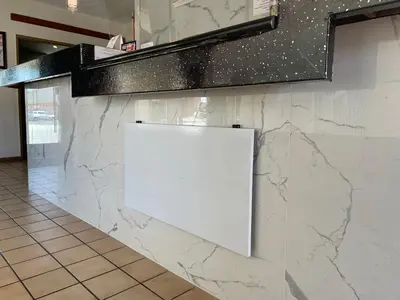 a white counter with a sign on a wall at Grand Inn in Fullerton