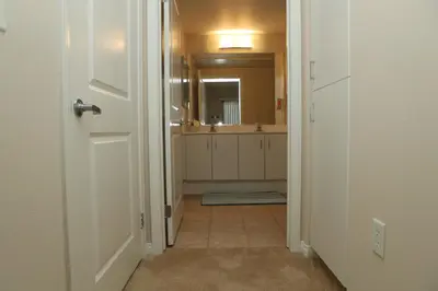 a hallway leading to a bathroom with a mirror at Amazing Apartments near the grove in Los Angeles
