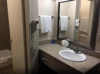 a bathroom with a sink and a mirror and a phone at Triplodge of Santa Clarita in Santa Clarita