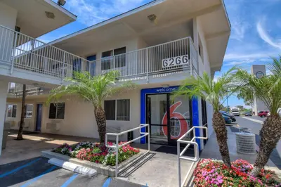 a building with palm trees in front of it at Motel 6-Westminster, CA - South - Long Beach Area in Westminster