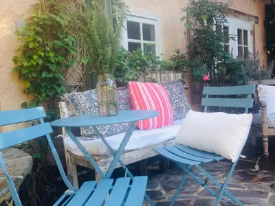 a table and two chairs and a bench with pillows at Under the Tuscan Sun Cottage in West Los Angeles in Los Angeles