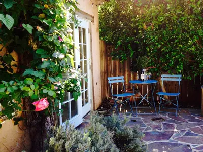 a patio with a table and chairs in front of a building at Under the Tuscan Sun Cottage in West Los Angeles in Los Angeles
