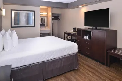 a hotel room with a bed and a flat screen tv at Tarzana Inn in Tarzana