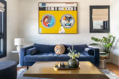 a living room with a blue couch and a table at Gold-Diggers in Los Angeles