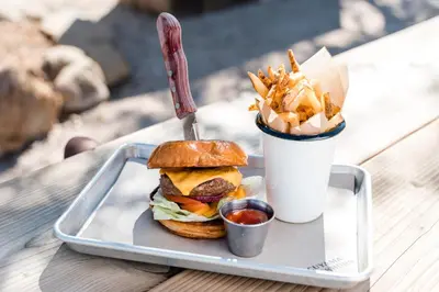a tray with a hamburger and french fries and a drink at Cuyama Buckhorn in New Cuyama