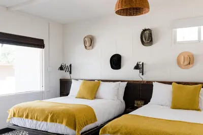two beds in a room with hats on the wall at Cuyama Buckhorn in New Cuyama