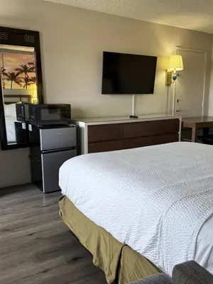 a hotel room with a bed and a flat screen tv at Days Inn by Wyndham Ontario Airport in Ontario