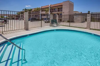 a swimming pool in front of a building at Days Inn by Wyndham Ontario Airport in Ontario