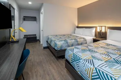 a hotel room with two beds and a desk at Motel 6-Fontana, CA in Fontana