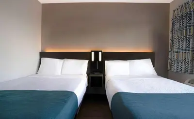 two beds sitting next to each other in a hotel room at Motel 6-Bakersfield, CA - South in Bakersfield