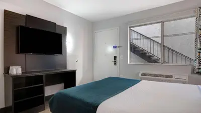 a hotel room with a bed and a flat screen tv at Motel 6-Bakersfield, CA - South in Bakersfield