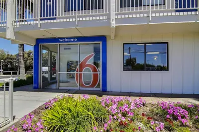 a welcome sign in front of a building with flowers at Motel 6-Carpinteria, CA - Santa Barbara - North in Carpinteria