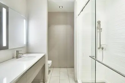 a white bathroom with a sink and a shower at AC Hotel by Marriott Beverly Hills in Los Angeles