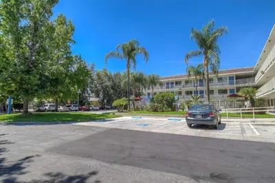 a car parked in a parking lot in front of a building at Motel 6-San Bernardino, CA - North in Serrano Village