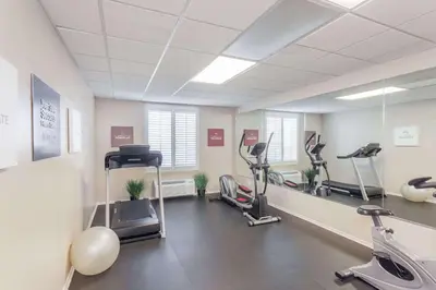 a gym with treadmills and ellipticals in a room at Hawthorn Suites in Victorville