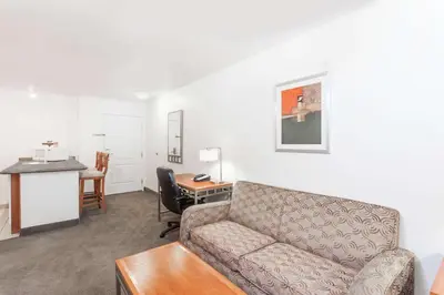 a living room with a couch and a desk at Hawthorn Suites in Victorville