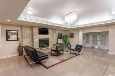 a living room with chairs and a fireplace at Hawthorn Suites in Victorville