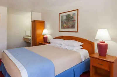 a bedroom with a large bed with two night stands and two lamps at Days Inn by Wyndham Castaic Six Flags Magic Mountain in Castaic