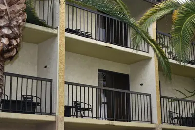 a building with tables and chairs on the balcony at Ontario Airport Inn in Ontario