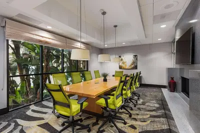 a dining room with a wooden table and yellow chairs at Hilton Garden Inn Los Angeles / Hollywood in Los Angeles