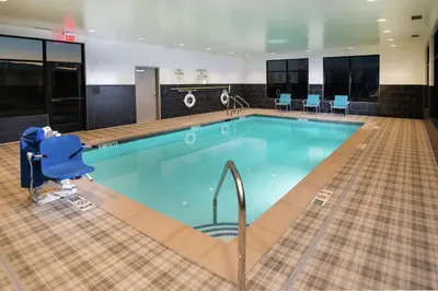 a swimming pool in a hotel with a blue chair in it at Hampton Inn Arvin Tejon Ranch, Ca in Wheeler Ridge
