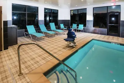 a pool in a room with chairs and tables at Hampton Inn Arvin Tejon Ranch, Ca in Wheeler Ridge