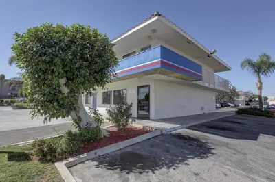 a building with a tree in front of it at Motel 6-Corona, CA in Corona