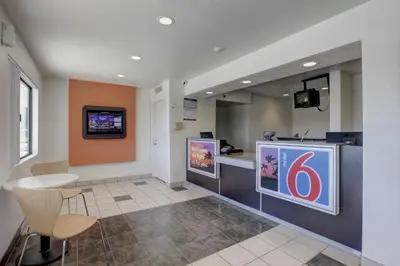 a waiting room with a table and a tv on the wall at Motel 6-Corona, CA in Corona