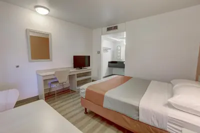 a hotel room with a bed and a desk with a computer at Motel 6-Corona, CA in Corona