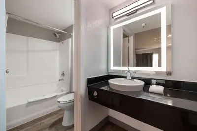 a bathroom with a sink and a toilet and a mirror at Motel 6-Santa Ana, CA in Santa Ana