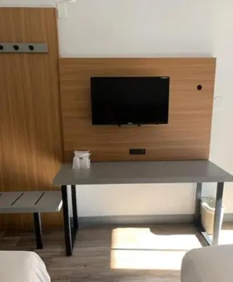 a room with a table with a television on a wall at Motel 6-Santa Ana, CA in Santa Ana