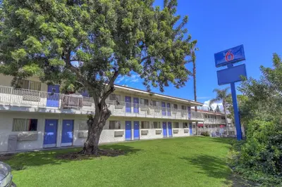 a building with a tree in front of a building at Motel 6 Chino, CA - Los Angeles Ontario in Chino