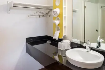 a bathroom with a white sink and a mirror at Motel 6-Bakersfield, CA - East in Bakersfield