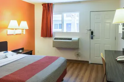 a hotel room with a bed and a desk and a window at Motel 6-Bakersfield, CA - East in Bakersfield