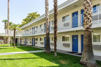 a building with palm trees in front of it at Motel 6-Bakersfield, CA - East in Bakersfield