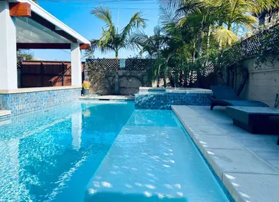 a swimming pool with blue water and palm trees at Oasis with pool and music studio by BENVENU in Los Angeles