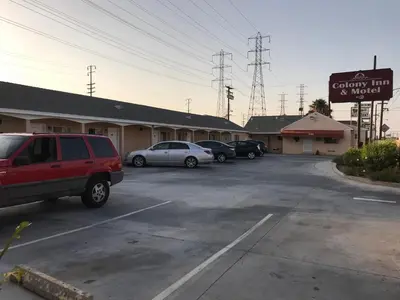 a parking lot with cars parked in front of a motel at Colony Inn Motel in Bellflower