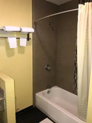 a bathroom with a white tub and a shower at Colony Inn Motel in Bellflower