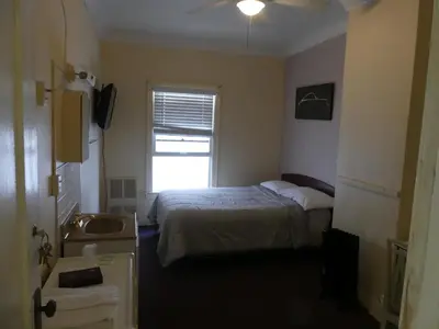 a bedroom with a bed and a sink and a window at Hotel del Flores in Los Angeles