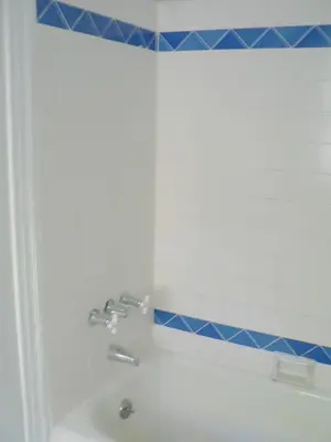 a bathroom with a white tub and blue tiles at Hotel del Flores in Los Angeles